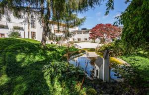 a building with a pond in front of a yard at Lovely Apartment In Stavanger With Kitchen in Stavanger