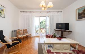 een woonkamer met een tafel en een televisie bij Stunning Apartment In Lovran With House Sea View in Lovran