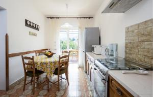 een keuken met een tafel en een tafel en stoelen bij Stunning Apartment In Lovran With House Sea View in Lovran