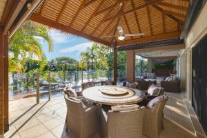 an outdoor dining room with a table and chairs at Habourlights 5BR River Front Private Pool & Dock in Gold Coast