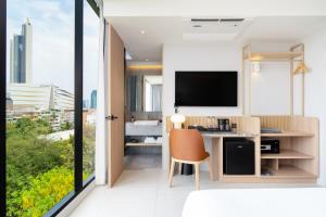 een kantoor met een bureau en een televisie in een kamer bij Saan Hotel Sathorn in Bangkok