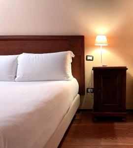 1 dormitorio con 1 cama y mesita de noche con lámpara en Palazzo Minelli, en Sala Bolognese