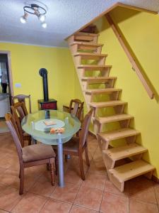 a spiral staircase with a table and a table and chairs at Apartma Pr Maruši in Bovec
