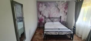 ein Schlafzimmer mit einem Bett und einer Wand mit Blumen in der Unterkunft Villa Visocchi Bed and Breakfast in Atina
