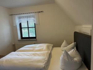 a bedroom with a bed with white sheets and pillows at Ferienhaus Waldeck in Marienberg