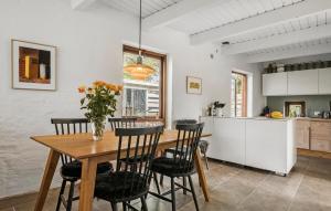 een keuken en eetkamer met een houten tafel en stoelen bij Pet Friendly Home In Eg With Wifi in Egå