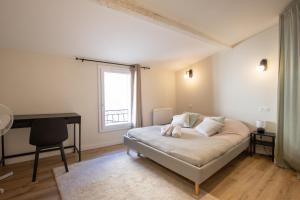 a bedroom with a bed and a desk and a window at L'antiquaire - 3 chambres - Hypercentre - Wifi in LʼIsle-sur-la-Sorgue