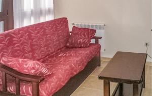 比利亞維西奧薩的住宿－2 Bedroom Lovely Apartment In Villaviciosa，客厅里一张红色的沙发,配有桌子