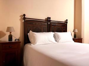 a bedroom with a bed with white sheets and pillows at Palazzo Minelli in Sala Bolognese