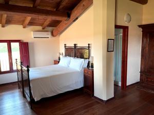 sypialnia z dużym białym łóżkiem i drewnianą podłogą w obiekcie Palazzo Minelli w mieście Sala Bolognese