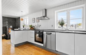 a kitchen with white cabinets and a stove at Amazing Home In Otterup With Kitchen in Otterup
