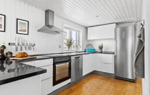 a kitchen with white cabinets and a stainless steel refrigerator at Amazing Home In Otterup With Kitchen in Otterup