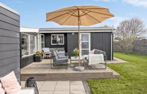 a patio with two chairs and an umbrella at Amazing Home In Otterup With Kitchen in Otterup +10 photos