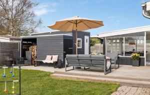 奧特魯普的住宿－Amazing Home In Otterup With Kitchen，一个带长凳和遮阳伞的庭院