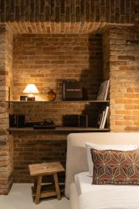 Cette chambre est dotée d'un mur en briques, d'un canapé et d'une table. dans l'établissement Hortus Vilnius, à Vilnius