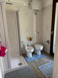 a bathroom with a shower and a toilet and a sink at SA DOA in Baratili San Pietro