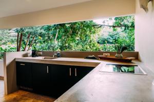 una cucina con un lavello e una grande finestra di Bohemi Design Villa's a Dorp Sint Michiel