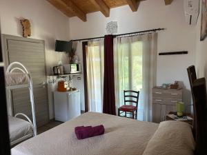 a bedroom with a bed and a kitchen with a window at SA DOA in Baratili San Pietro