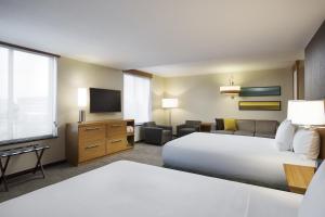 a hotel room with two beds and a television at Hyatt Place Chicago Midway Airport in Bedford Park