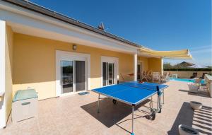 - une table de ping-pong devant une maison dans l'établissement Awesome Home In Visocane With Wi-fi, à Visočane