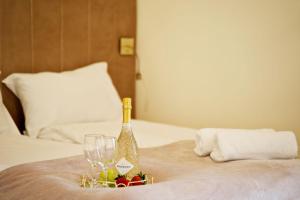 a bottle of champagne and glasses on a bed at Apartament Thaddeus 48 z tarasem in Zator