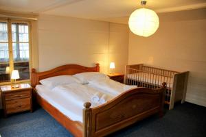 - une chambre dotée d'un grand lit avec des draps blancs et une lampe dans l'établissement Family-friendly chalet apt with balcony, à Meiringen