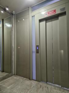une rangée de portes d'ascenseur dans un bâtiment dans l'établissement Apartament XIII piętro STADION NARODOWY, à Varsovie