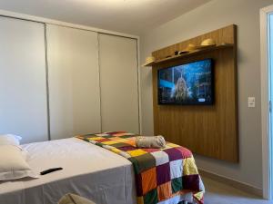 Schlafzimmer mit einem Bett und einem Flachbild-TV in der Unterkunft Cobertura Reformada Copacabana in Rio de Janeiro
