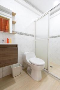 a white bathroom with a toilet and a shower at Lindo loft en corazón de Medellín Pet Friendly 206 in Medellín