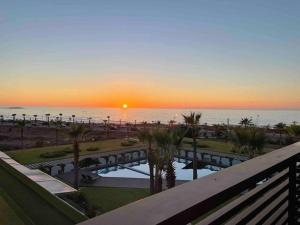 a sunset over the ocean from a balcony of a resort at 360 ocean view 2-bedroom lovely apartment in Tamaris
