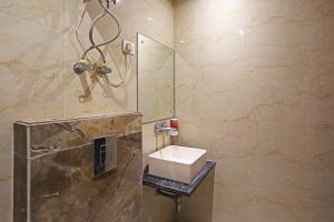 uma casa de banho com um lavatório e um chuveiro em The Rose Manor By Iconic Delhi International Airport em Nova Deli