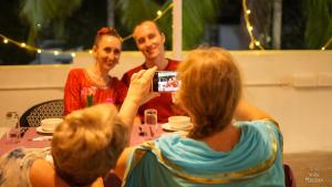 a woman taking a picture of two men sitting at a table at VILLA MANTRAA in Varkala