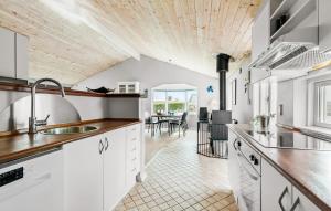 eine Küche mit weißen Schränken und einer Holzdecke in der Unterkunft Three-Bedroom Holiday Home In Glesborg in Glesborg