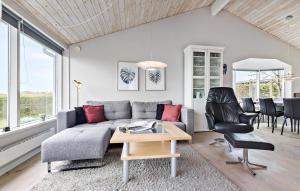 ein Wohnzimmer mit einer Couch und einem Tisch und Stühlen in der Unterkunft Three-Bedroom Holiday Home In Glesborg in Glesborg