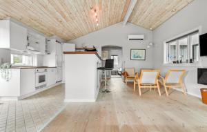 eine Küche und ein Esszimmer mit weißen Schränken und Stühlen in der Unterkunft Three-Bedroom Holiday Home In Glesborg in Glesborg