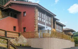 una casa grande con una valla de madera delante de ella en 2 Bedroom Amazing Apartment In Villaviciosa en Villaviciosa