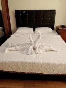 deux cygnes faisant un cœur sur un lit dans l'établissement BALŞEN HOTEL, à Anamur
