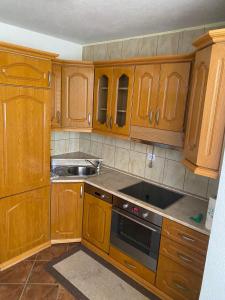 a kitchen with wooden cabinets and a sink at Apartments-Asquiro in Raskršće