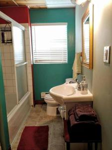 La salle de bains est pourvue d'un lavabo, de toilettes et d'une fenêtre. dans l'établissement Loft La Coquille de Lune, à Sainte-Rose-du-Nord