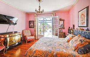 a bedroom with pink walls and a bed and a television at Lovely Home In Saint-Julien-Les-Rosie in Saint Julien Les Rosiers +16 photos