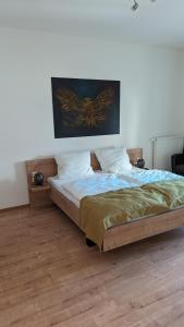 una camera da letto con un letto e un dipinto sul muro di Ferienwohnungen Lehnerwirt a Breitenbrunn