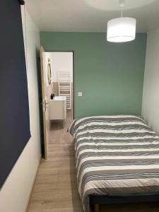 een slaapkamer met een bed en een badkamer met een wastafel bij Gîte à Travers champs in Colombières