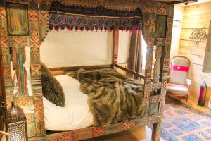 - une chambre avec un lit à baldaquin dans l'établissement La Ferme du Lac Vert, à Montriond