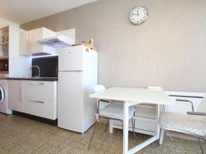 eine Küche mit einem weißen Kühlschrank und einem Tisch in der Unterkunft Studio Balaruc-les-Bains, 1 pièce, 2 personnes - FR-1-553-41 in Balaruc-les-Bains