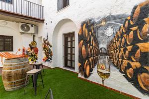 um mural na lateral de um edifício com relva verde em Allo Apartments Arroyo Catedral em Jerez de la Frontera