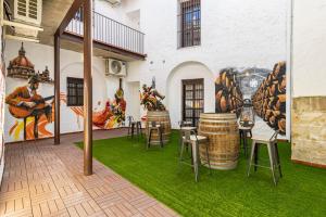 um quarto com uma mesa e cadeiras e um mural em Allo Apartments Arroyo Catedral em Jerez de la Frontera