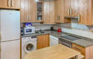 a kitchen with a white refrigerator and a dishwasher at Gorgeous Apartment In San Juan De La Arena With Wifi in San Juan de la Arena