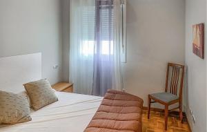 a bedroom with a bed with a chair and a window at Gorgeous Apartment In San Juan De La Arena With Wifi in San Juan de la Arena