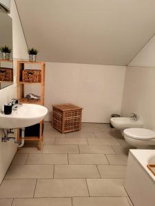 a bathroom with two sinks and a toilet and a sink at Großschlipfhof in Silandro