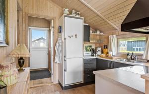 a kitchen with a white refrigerator in a tiny house at Awesome Home In Svendborg With Kitchen in Svendborg
